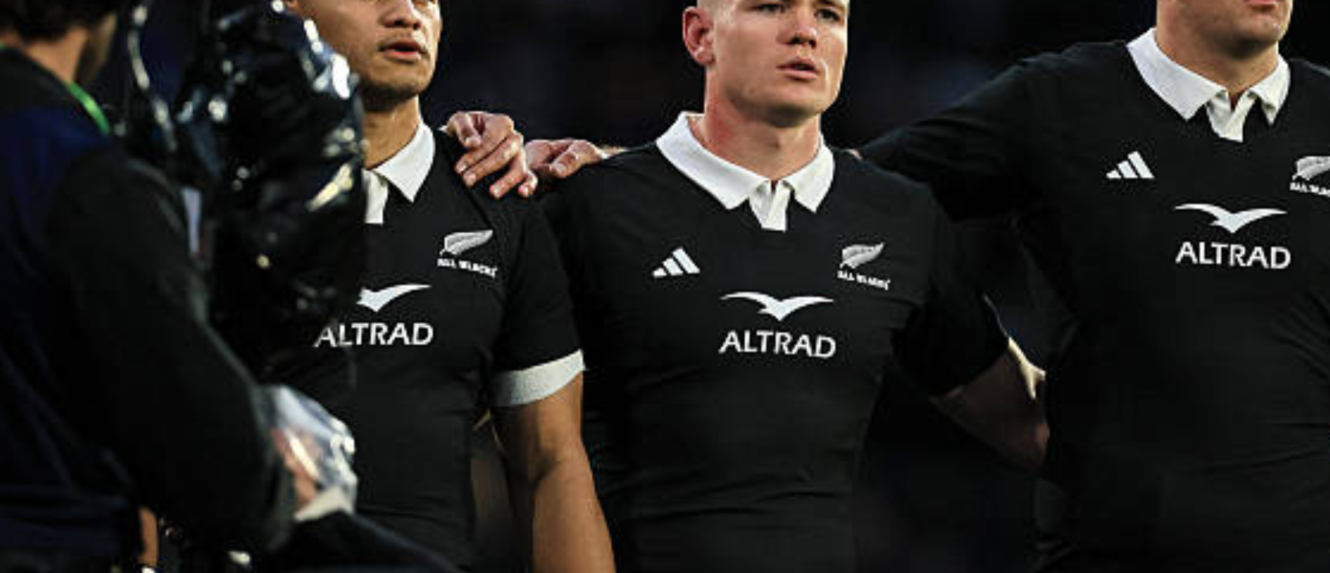 Anton Segner of New Zealand (C) sings the national anthem with Wallace Sititi (L) and Sam Darry (R) during the rugby union Nations Championship match between the New Zealand All Blacks and Italy in HNRY Stadium in Wellington on July 11, 2026. (Photo by Grant Down / AFP via Getty Images)