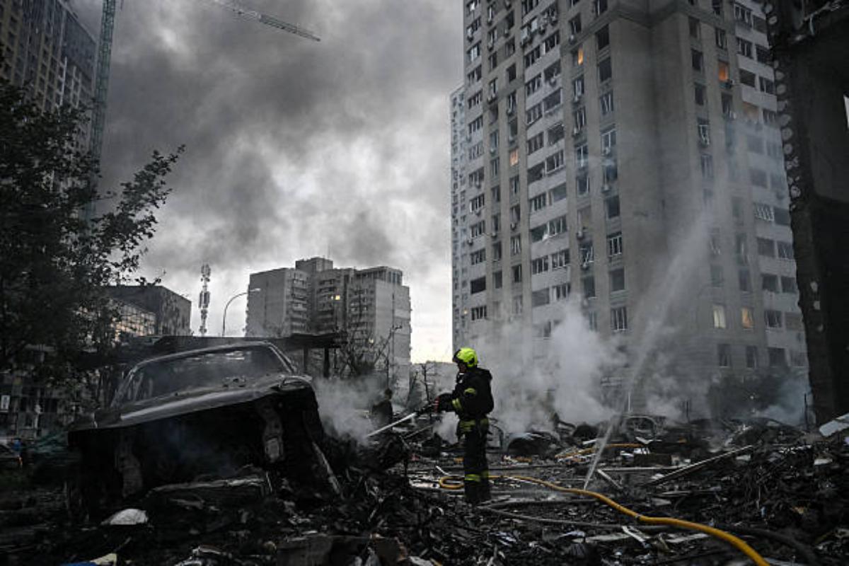 A rescuer extinguishes burning cars parked outside a multistorey residential building damaged following a Russian missile strike on the Ukrainian capital of Kyiv on July 6, 2026 in Ukraine. Photo: Genya Savilov/AFP via Getty Images