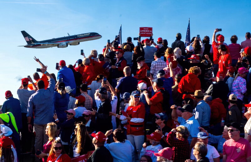 A private jet branded "TRUMP" flies over a rally displaying a "MAKE AMERICA GREAT AGAIN" sign in WASHINGTON D.C. on 09/06/2026.