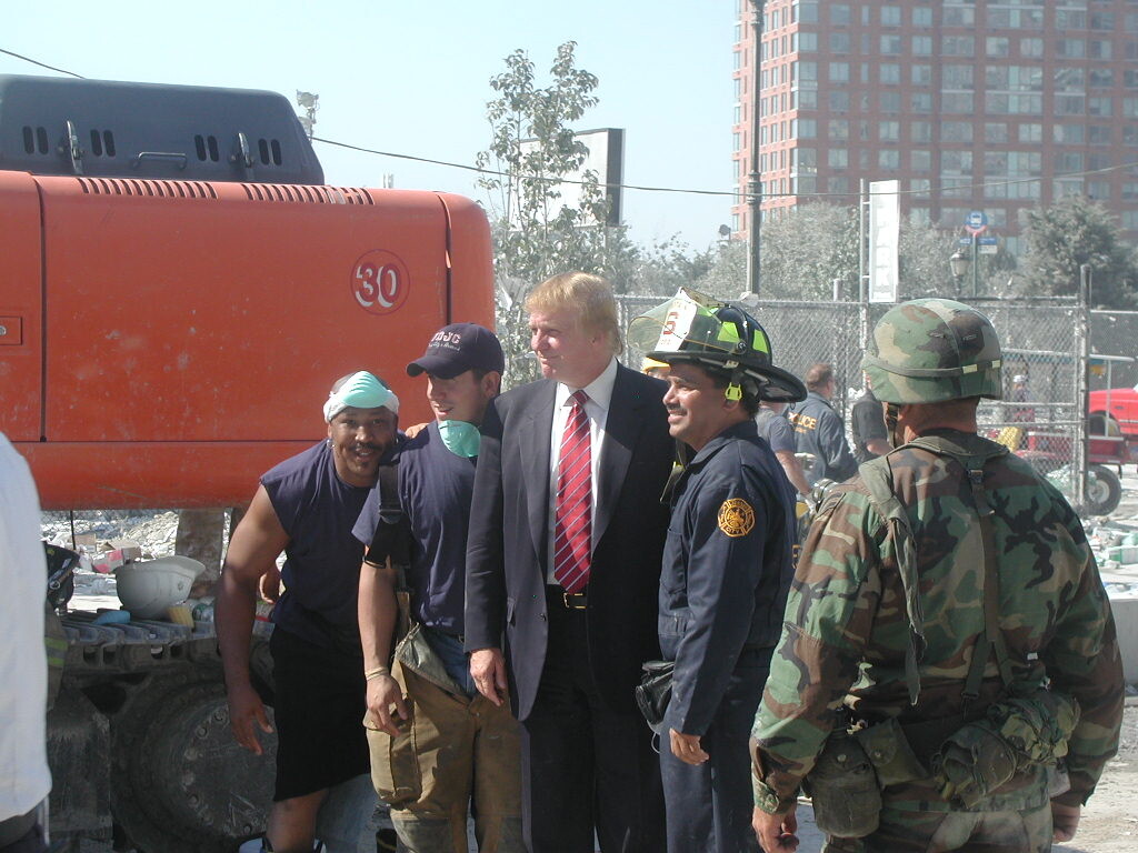 Emergency and recovery personnel gather at a debris-strewn outdoor site on 09/08/2026. President Donald J.